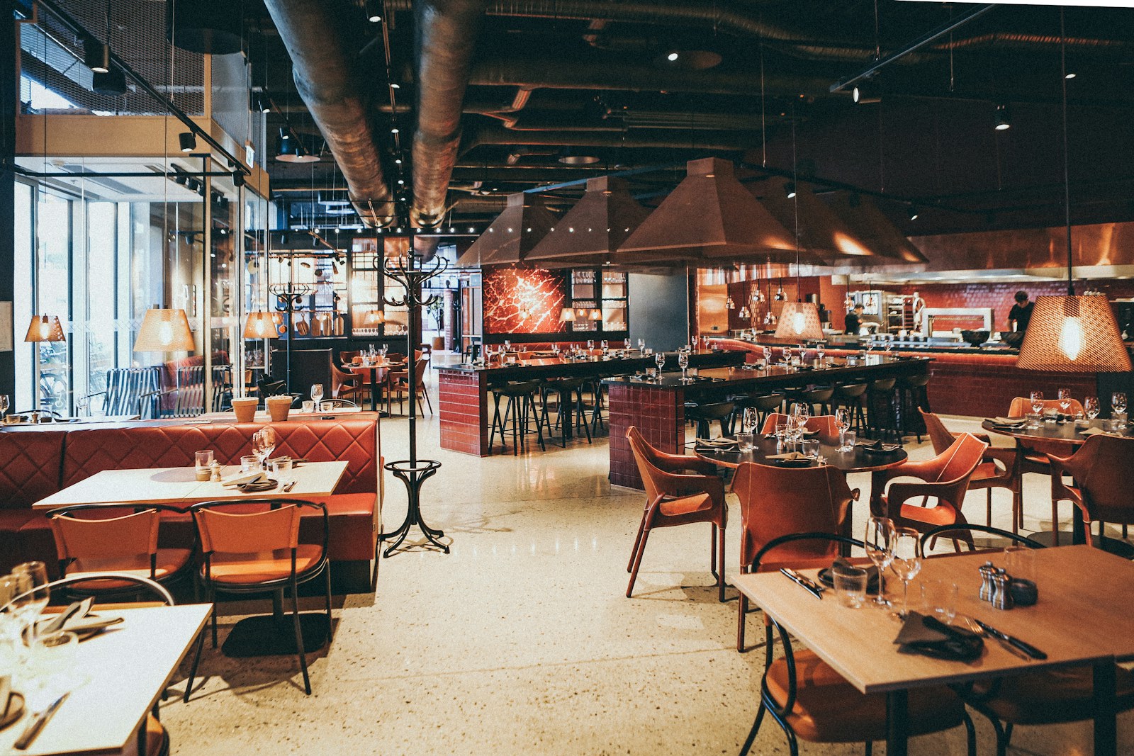 Warm restaurant interior with timber tables, brick walls, and pendant lighting