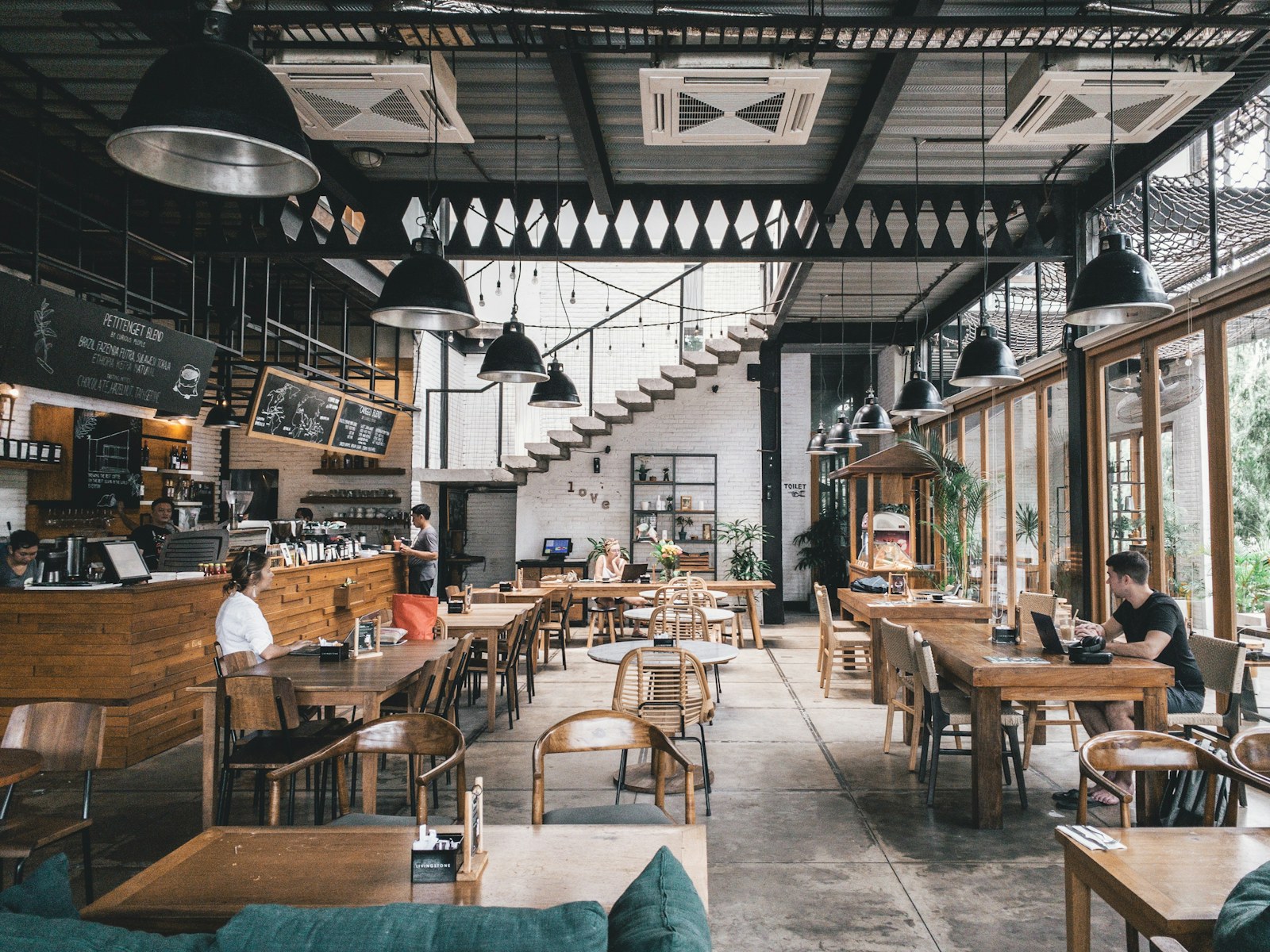 Warm restaurant dining room with timber tables and soft light