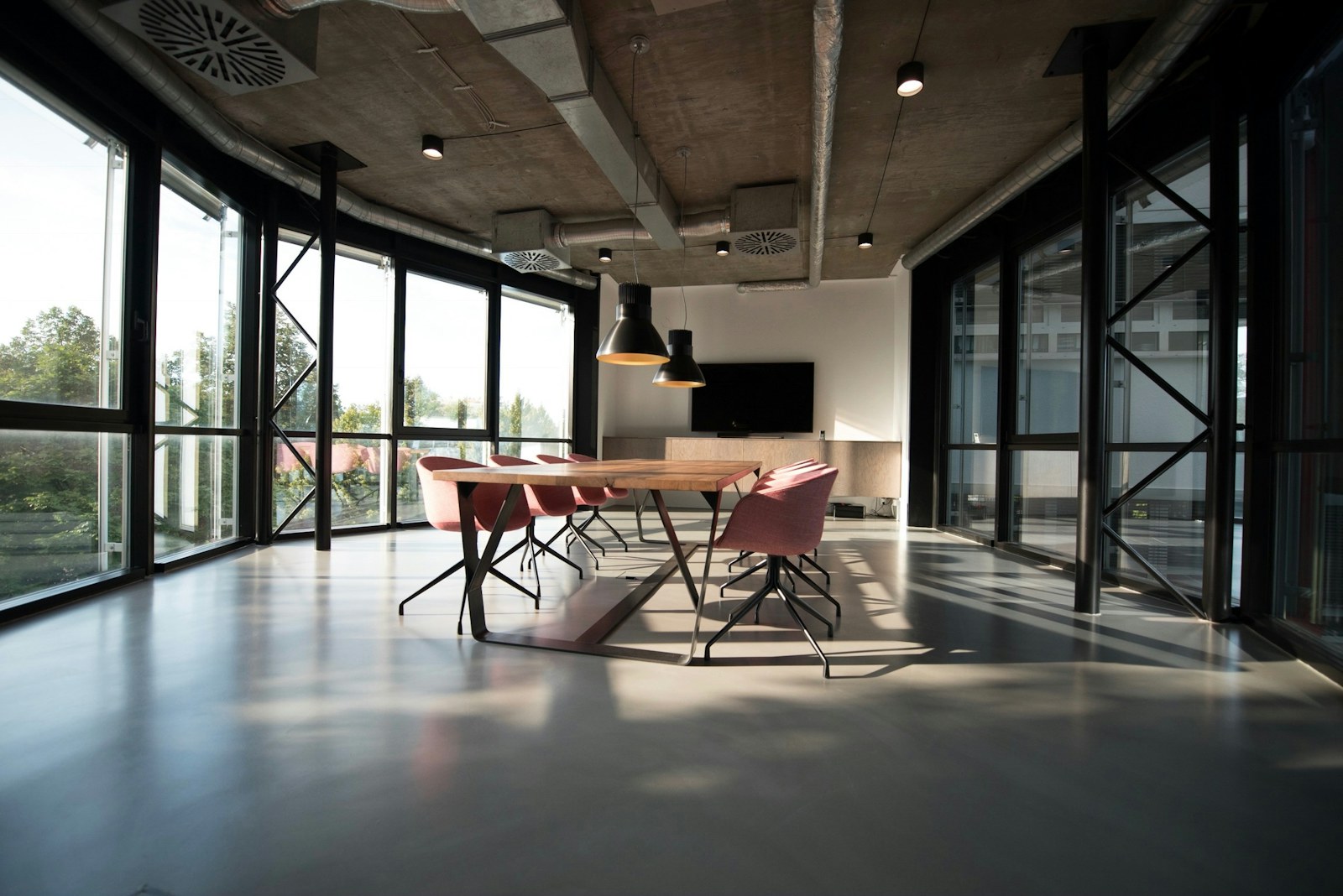 Sunlit studio interior with a long table and floor-to-ceiling windows